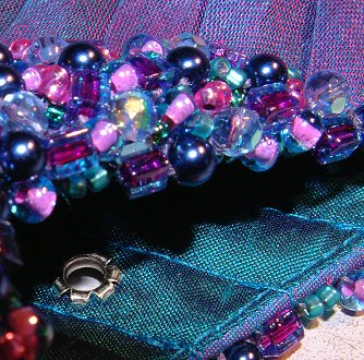 The jewels take it to another level. Cut glass beads give flashes of rainbow light, peacock blue pearls and sea-green crystals combine to provide even more depth of colour - blues and greens mixing in all possible tones.  