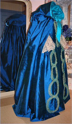 A matching full length hooded cloak was designed to go with the midnight blue silk eighteenth century style ballgown.  The hood was lined in a blending turquoise silk, which was also used for the ribbon fastenings and a pleated trim around the hood edge.