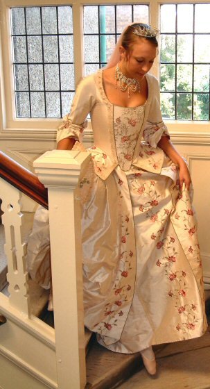 A stunning eighteenth century style wedding dress in cloud pink regal dupion. This period style wedding gown consists of a corseted jacket/ bodice with a seperate skirt worn over pannier supports.