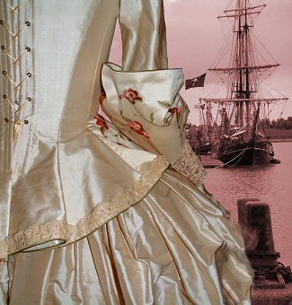 The bodice is corseted and laced at the back to achieve a corset-like finish. It has fitted, elbow-length sleeves ending in large, romantic cuffs with lace sleeve flounces. The skirt has an open front to show off the beautiful scrolling floral embroidery and draped panniers, again edged in lace.