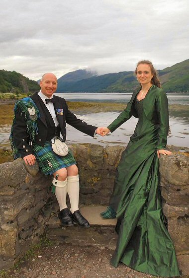The colour was chosen to co-ordinate with her husband-to-be's O'Connor clan tartan; it proved to complement the highland landscape perfectly. The tartan theme was continued with her hand-made victorian style boots.  The boned bodice was enhanced with scattered bugle beads in petrol shades around the neckline.  A matching cropped bolero/ shrug jacket was also designed.  Although a midsummer wedding,it took place in a scottish castle and some protection against possible chills was needed.