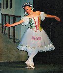 Swanilda's Act I peasant costume in green, white and pink, consists of a silk dupion bodice with a decorated brocade stomacher with false lacing.  Tassets at the waist and seam lines are piped in a contrasting colour.  The multi-layered tulle skirt is edged in lace. 
The costume was made to the highest couture / theatrical standards in order to withstand the rigours of many performances.