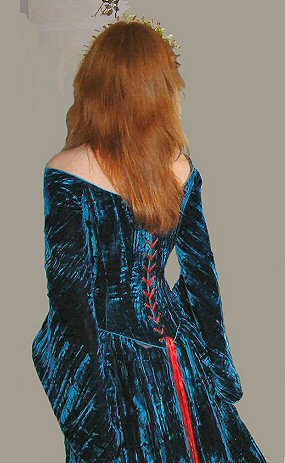 back view of petrol blue velvet corset laced with contrasting red ribbon