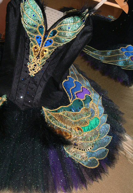 black/purple/green/ coloured tutu, embellished with swan wings in shot and iridescent purple, green, blue and gold